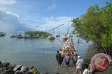 Sejumlah nelayan menggotong rakit pohon pisang berisi sesaji yang akan dilarung dalam upacara petik laut, di Desa Branta Tinggi, Tlanakan, Pamekasan, Jatim, Selasa (14/4). ANTARA FOTO/Saiful Bahri/wdy/15.