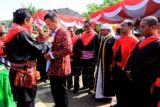 Walikota Pangkalpinang Muhammad Irwansyah (kedua kiri) memperoleh gelar adat "Upu Hini Amboina' (orang besar yang sangat dihargai jasanya bagi orang Maluku di tanah rantau) dari Ketua Majelis Latupati (Dewan Adat) Kota Ambon John L. Rehatta (kiri) di pelataran Monumen Gong Perdamaian Dunia, Ambon, Maluku, Jumat (17/4). Gelar adat tersebut diberikan karena Muhammad Irwansyah dinilai sangat berjasa memberikan perhatian dan dukungan bagi warga asal Maluku yang menetap di Pangkalpinang. ANTARA FOTO/Izaac Mulyawan/ss/Spt/15