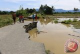 Sejumlah bocah bermain di titik ruas badan jalan sepanjang 50 meter yang terputus dan ambruk sedalam 1,5 meter di Desa Seumantok, Kecamatan Pante Cereumen, Kabupaten Aceh Barat, Provinsi Aceh, Minggu (19/4). Selain menyebabkan ribuan warga megungsi banjir bandang melanda pedalaman Aceh Barat ini merusak tiga unit jembatan, rumah penduduk serta tidak banyak harta benda yang berhasil diselamatkan warga karena banjir yang datang tiba-tiba.(ANTARAACEH.COM/Anwar)