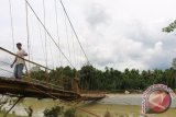 Warga menaiki jembatan gantung sepanjang 250 meter yang hancur diterjang banjir bandang menghubungkan Desa Menuang Kinco, Kecamatan Pante Cereumen, Kabupaten Aceh Barat, Provinsi Aceh, Minggu (19/4). Selain merusak tiga jembatan dan memutuskan badan jalan 50 meter, empat desa kawasan itu masih terisolir akibat diterjang banjir bandang pada Jum'at (17/4) malam sehingga membuat warga setempat terkurung banjir.(ANTARAACEH.COM)