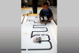 Seorang peserta mengoperasikan robot pada "Java Robot Contest 2015" di Politeknik Elektronika Negeri Surabaya (PENS), Surabaya, Jawa Timur, Minggu (19/4). Kompetisi robotika yang mengangkat tema "Suroboyo: Sinau Robot lan Budoyo" diikuti peserta dari tingkat nasional dari jenjang pendidikan SD, SMP, dan SMA sebanyak 127 tim tersebut bertujuan untuk mengenal permainan tradisional pada perkembangan teknologi saat ini. ANTARA FOTO/M Risyal Hidayat/Rei/1nz/5.
