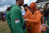 Ketua DPRD Kabupaten Gorontalo Utara Nurjanah Yusuf Mopili turut menyematkan ban ke anggota Yonif 715 dalam atraksi memeriahkan HUT Kabupaten Gorontalo Utara ke-8. (foto adv/Susanti Sako)