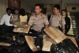 Kapolres Banda Aceh Kombes Pol Zulkifli (ketiga kanan) menggelar barang bukti puluhan paket ganja kering siap edar yang dibalut dengan plastik hitam di Banda Aceh, Rabu (29/7). Empat koper berisi sebanyak 51 bal ganja kering yang akan diselundupkan ke Jakarta melalui bandara Internasional Sultan Iskandar Muda itu berhasil digagalkan dan polisi mengamankan tersangka IR asal Ambon. ANTARA FOTO/Ampelsa/Rei/nz/15.