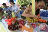 Peserta merangkai buah yang dilombakan pada Gerakan Makan Buah di Palu, Sulawesi Tengah, Kamis (30/4). Kementerian Pertanian mendorong warga untuk makan buah karena tingkat konsumsi buah di Indonesia masih rata-rata sebesar 34 kilogram per kapita per tahun, jauh berada di bawah standar Food Agriculture Organisation (FAO) sebanyak 73 kilogram per kapita per tahun. ANTARA FOTO/Basri Marzuki/wdy/15.