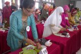 Kediri (Antara Jatim) - Peserta lomba mengiris bawang merah mencelupkan bawangnya sebelum diiris tipis dalam lomba di gedung Bhagawantabari Kabupaten Kediri, Jawa Timur, Selasa (21/4). Pemkab mengadakan sejumlah lomba memeringati Hari Kartini, salah satunya mengiris bawang merah. foto Asmaul Chusna/14/Chan.