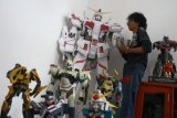Malang (Antara Jatim).- Hafest (27) membuat replika robot dari karakrer film kartun Gundam dan Tranformers di kelurahan Tunjungsekar, Malang, Jawa Timur, Jumat (17/4). Replika robot kartun tersebut dibuat dari kertas dengan ukuran 20 centimeter hingga 1,8 meter. FOTO Ari Bowo Sucipto/15/Chan.