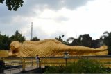 ?
Mojokerto (Antara Jatim) - Pengunjung memperhatikan  patung Buddha tidur yang dibangun di Desa Bejijong, Trowulan, Mojokerto, Jatim, Sabtu ((11/4). 
Patung Buddha tidur yang dibandun. 1993 dengan warna keemasan  memiliki panjang 22 meter dengan lebar 6 meter dan tinggi 4,5 meter. Lokasi ini menjadi obyek wisata alternatif yang kini banyak dikunjungi wisatawan. Foto Reswidya Singgih/15/SHP