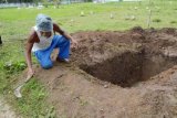 Madiun (Antara Jatim) - Petugas makam membersihkan rumput di sekitar liang lahat tempat rencana Raheem Agbeja Salami terpidana mati dimakamkan, di Makam Umum Kelurahan Taman, Kota Madiun, Senin (27/4). Liang lahat tersebut telah digali sejak 11 Maret lalu, beberapa hari setelah Raheem terpidana mati kasus 5 kg heroin asal Kordoba, Spanyol itu dipindahkan dari Lembaga Pemasyarakatan Madiun ke Nusakambangan, Rabu (4/3). FOTO Siswowidodo/15/Uki