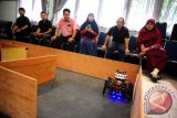 Sejumlah akademisi dan wartawan menyaksikan atraksi robot pendeteksi kebakaran saat eksibisi di ruang sidang Fakultas Teknik Universitas Tanjungpura, di Pontianak, Kalbar, Kamis (30/4). Robot pendeteksi api kebakaran buatan tim kreatif dari Fakultas Teknik Universitas Tanjungpura tersebut, akan diikutkan dalam Kontes Robot Indonesia di Banjarmasin, Kalimantan Selatan pada 7-9 Mei mendatang. ANTARA FOTO/Jessica Helena Wuysang/15