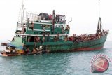 Imigran suku Rohingya dari Myanmar yang terdampar dibantu nelayan Aceh di perairan Desa Simpang Tiga, Kecamatan Julok, Aceh Timur, Aceh, Rabu (20/5). Sebanyak 400 Imigran itu terdampar dan ditemukan nelayan Aceh sekitar 26 mil dari pesisir pantai Desa Simpang Tiga. ANTARA FOTO/Syifa/Irp/Rei/Spt/15.