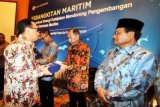 Gubernur Bank Indonesia Agus DW Martowardojo (kiri) menyerahkan cinderamata kepada Gubernur Maluku Said Assagaff saat Rapat Koordinasi Bank Indonesia, Pemerintah Pusat dan Pemerintah Daerah yang berlangsung di Ambon, Maluku, Senin (25/5). Rakor yang dihadiri Gubernur Bank Indonesia Agus DW Martowardojo juga dihadiri perwakilan Pemprov Maluku, Maluku Utara, Papua dan Papua Barat. Rakor membahas program-program guna memperkuat sinergi kebijakan guna mendorong pengembangan ekonomi berbasis maritim. ANTARA FOTO/Izaac Mulyawan/Rei/nz/15.