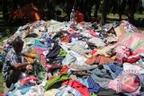 Imigran etnis Rohingya yang terdampar di perairan Aceh memilih baju bekas ditempat penampungan sementara di Desa Bayeun, Kecamatan Rantoe Seulamat, Kabupaten Aceh Timur, Aceh, Jumat (29/5). Pemerintah Indonesia dan Malaysia berencana akan melakukan reunifikasi atau mempertemukan anggota keluarga suku Rohingya dari Myanmar yang terdampar di Aceh dan Malaysia dan teknis reunifikasi sedang ditangani Kementerian Luar Negeri dari kedua negara. ANTARA FOTO/Syifa/Irp/ss/pd/15.
