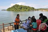 Pengunjung berada di lokasi wisata pelabuhan alam, Calang, Kabupaten Aceh Jaya, Aceh, Sabtu (30/5). Kabupaten Aceh Jaya yang berada di wilayah pesisir barat propinsi Aceh itu, memiliki pantai yang indah karena berlatar alam pegunungan dan sejumlah pulau kecil dengan aneka keragaman biota laut. ACEH.ANTARANEWS.COM/Ampelsa/15
