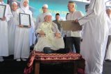 Surabaya (Antara Jatim) -  KH Bashori Alwi selaku pengasuh Pesantren Ilmu Al-Quran, Singosari, Malang memantau langsung Munaqosah (Ujian) Terbuka untuk Pembacaan Al-Quran yang diikuti 92 dari 500-an siswa SMP Khadijah, Wonokromo, Surabaya, Jawa Timur, yang telah lulus ujian tertutup dan dipantau langsung KH Bashori Alwi selaku pengasuh Pesantren Ilmu Al-Quran, Singosari, Malang di halaman SMP Khadijah, Wonokromo, Surabaya, Minggu (10/5). SMP Khadijah, Wonokromo, Surabaya, menjadikan Al-Quran sebagai syarat kelulusan siswa. Foto Edy M Ya'kub/15/SHP