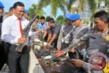 Anggota Polda Aceh memperlihatkan barang bukti kejahatan berupa senjata api laras panjang, amunisi dan sejumlah barang bukti lainnya milik kelompok kriminal bersenjata Din Minimi saat gelar perkara di Mapolda Aceh, Banda Aceh, Rabu (27/5). Barang bukti itu antara lain berupa senjata AK56, senjata SS1 V3, senjata GLM, granat manggis, amunisi GLM, 1.577 butir amunisi M16 dan AK56 serta beberapa buah rompi militer dan baju loreng yang berhasil diamankan pasca penggerebeken kelompok kriminal bersenjata Din Mini pada Selasa (26/5) di kecamatan Tangse, Kabupaten Pidie, Aceh. ANTARA FOTO/Ampelsa/WDY/15
