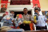 Kapolres Lamongan AKBP Trisno Rahmadi (tengah) menunjukan tersangka spesialis perampokan nasabah bank serta barang bukti kejahatan saat press rilis di Mapolres Lamongan, Jawa Timur, Jumat (15/5). Satreskrim Polres Lamongan berhasil menangkap lima perampok spesialis nasabah bank di wilayah Lamongan yakni Adi Cahyono, Adi Saputra, Ahmad Wahyudi Sahrudin, Bendi Setiawan warga Palembang. Selain mengamankan pelaku polisi juga menyita barang bukti 2 unit sepeda motor, kunci T, 5 buah HP, uang tunai sebesar Rp15 juta, 5 buku tabungan, 9 ATM. Tersangka diancam Pasal 363 KUHP dengan hukuman 7 tahun penjara. Antara Jatim/Foto Syaiful Arif/15/Chan.