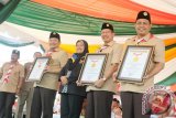 Menteri Agama Lukman Hakim Saifudin, Wakil Gubernur Rudy Resnawan dan Wakil Kwarnas Pramuka Marbawi memegang perhargaan Rekor MURI pada pembukaan Perkemahan Pramuka Santri Nusantara IV di Bumi Perkemahan Agro Wisata Tambang Ulang Kabupaten Tanah Laut Kalimantan Selatan, Selasa (2/6). PPPSN IV yang digelar 1-7 Juni 2015 yang diikuti 5000 peserta dari 33 provinsi tersebut memecahkan rekor pelantun seni bertutur Madihin (seni khas Banjar) terbanyak mencapai 5859 peserta. Foto Antaranews Kalsel/Herry Murdy Hermawan