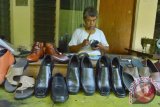 Perajin menyelesaikan pembuatan sepatu di industri rumahan kawasan sentra industri kerajinan kulit di Magetan, Jawa Timur, Kamis (4/6). Menurut perajin, menjelang lebaran, produksi alas kaki (sepatu dan sandal) di industri rumahan tersebut mengalami peningkatan sekitar 30 persen dari sebelumnya 30 pasang menjadi 40 pasang perhari, seiring meningkatnya permintaan pasar. Antara Jatim/Foto/Siswowidodo/15