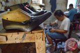 Perajin menyelesaikan pembuatan sepatu di industri rumahan kawasan sentra industri kerajinan kulit di Magetan, Jawa Timur, Kamis (4/6). Sepatu produksi Magetan dikenal sebagai sepatu berbahan kulit berkualitas tinggi, namun harga relatif murah, antara Rp 75 ribu hingga Rp 225 ribu perpasang. Antara Jatim/Foto/Siswowidodo/15