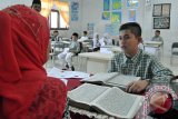 Guru melakukan tes kemampuan baca Alqur'an kepada calon murid baru di sekolah unggul SMP 6, Banda Aceh, Jumat (12/6). Tes kemampuan baca Alqur'an disertai wawancara bagi calon murid baru di sekolah unggul itu,  untuk mengukur kemampuan dan potensi murid, sekaligus mencari bakat bagi mereka yang  memiliki nilai lebih dibidang agama. ACEH.ANTARANEWS.COM/Ampelsa/15
