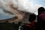 Warga melihat ke arah gunung ketika terjadi luncuran awan panas guguran kubah lava di kawasan Namanteran, Karo, Sumatera Utara, Minggu (14/6). Gunung Sinabung yang berstatus Awas membuat sedikitnya 3000 jiwa harus dievakuasi dari desa tempat tinggal mereka yang terletak di sisi tenggara dan gunung tersebut. ANTARA FOTO/Rony Muharrman/ed/foc/15