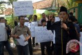 Sejumlah guru yang tergabung dalam Forum Guru Non PNS Pamekasan (FGNP) berunjukrasa, di depan kantor Kemenag, Pamekasan, Jatim, Rabu (17/6). Mereka menuntut  Kemenag setempat untuk segera mencairkan dana tunjangan sertifikasi guru non PNS yang tidak dibayar selama 12 bulan dan 14 bulan untuk guru PNS. Antara Jatim/Foto/Saiful Bahri/15