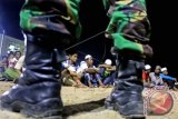 Pengungsi Rohingya mengikuti apel kelengkapan dengan penjagaan dari aparat keamanan di tempat penampungan sementara Desa Blang Ado, Aceh Utara, Aceh. Rabu (17/6) malam. Apel tersebut dilakukan pagi dan malam hari untuk mengantisipasi kaburnya pengungsi Rohingya dari tempat penampungan. ANTARA FOTO/Rahmad/Rei/foc/15.