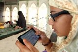 Warga membaca Alquran digital menggunakan telepon seluler di Masjid Raya Makassar, Sulawesi Tenggara, Kamis (18/6). Kementerian Agama menghimbau masyarakat agar menggunakan Alquran versi elektronik atau digital yang telah tersertifikasi oleh lembaga kredibel untuk menghindari penyimpangan dari isi aslinya. ANTARA FOTO/Ekho Ardiyanto/ss/kye/15