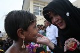 Walikota Banda Aceh Illiza Sa'aduddin Djamal (kanan) menyapa anak imigran Rohingya asal Myanmar saat menyerahkan bantuan dan berbuka puasa bersama di tempat penampungan sementara di Desa Blang Ado, Kecamatan Kuta Makmur, Kabupaten Aceh Utara, Aceh, Kamis (18/6). Pemerintah Kota Banda Aceh menyerahkan bantuan Rp200 juta yang dikumpulkan dari Pegawai dan para guru sebagai wujud kepedulian terhadap imigran Rohingya dari Myanmar. ANTARA FOTO/Irwansyah Putra/ss/kye/15.