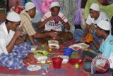 Sejumlah Imigran Rohingya berbuka puasa bersama pada hari pertama bulan suci Ramadan di tempat penampungan sementara Desa Bayeun, Kecamatan Rantoe Seulamat, Kabupaten Aceh Timur, Aceh, Kamis (18/6). Seluruh pengungsi Rohingya yang menempati empat lokasi penampungan di Aceh Utara, Aceh Timur, Langsa dan Aceh Tamiang melaksanakan ibadah puasa pertama di posko pengungsian. ANTARA FOTO/Syifa/kye/15.