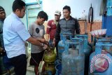 Petugas Satreskrim Polres Sidoarjo menunjukkan proses pengoplosan gas elpiji bersubsidi 3 kg ke tabung gas elpiji 12 kg saat penggrebekan industri pengoplos elpiji di kawasan Desa  Cemengkalang, Sidoarjo, Jawa Timur, Sabtu (20/6). Petugas berhasil mengamankan dua tersangka pemilik dua industri pengoplos gas elpiji 3 kg bersubsidi kedalam tabung 12 dan 40 kg non subsidi dengan keuntungan Rp20 ribu untuk tabung elpiji 12 kg dan Rp65 ribu untuk tabung ukuran 40 kg. Antara Jatim/Umarul Faruq/Zk/15