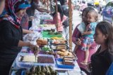 Pedagang melayani pembeli pada Bursa Kue Ramadan di Desa Batumerah, Ambon, Maluku, Kamis (18/6). Desa Batumerah dikenal sebagai kampung kuliner di Kota Ambon yang menyediakan puluhan lapak khusus untuk menjajakan aneka makanan dan minuman buka puasa selama Ramadan. ANTARA FOTO/Embong Salampessy/ss/Spt/15.