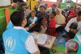 Petugas UNHCR membagikan sertifikat pencari suaka kepada Imigran Rohingya asal Myanmar di tempat penampungan sementara Desa Bayeun, Kecamatan Rantoe Seulamat, Aceh Timur, Aceh, Senin (22/6). Menurut data dari petugas UNHCR, Sebanyak 340 Sertifikat pencari suaka untuk sementara dibagikan kepada Imigran Rohingya Asal Myanmar yang menempati penampungan Aceh Timur. ANTARA FOTO/Syifa/wdy/15.