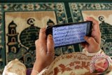 Warga membaca Alquran digital menggunakan telepon seluler di Masjid Raya Makassar, Sulawesi Tenggara Kementerian Agama mengimbau masyarakat  menggunakan Alquran versi elektronik atau digital yang telah tersertifikasi oleh lembaga kredibel untuk menghindari penyimpangan dari isi aslinya. (ANTARA FOTO/Ekho Ardiyanto/Dok).