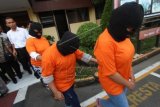 Petugas menggiring tiga orang ibu rumah tangga yang menjadi tersangka narkoba saat gelar kasus di Mapolresta Medan, Sumatera Utara, Senin (22/6). Polisi menangkap tiga ibu rumah tangga yang menjadi kurir narkoba jenis sabu seberat 700 gram dalam bentuk lima bungkus kecil siap jual. ANTARA FOTO/Septianda Perdana/ed/kye/15