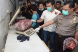 Kombes Pol Yan Fitri Halimansyah menunjukan daging oplosan yang merupakan daging babi saat pengerebekan di sebuah rumah yang dijadikan gudang dikawasan Jalan Penjernihan, Surabaya, Jawa Timur, Jumat (26/6). Dalam pengerebekan oleh Kepolisian Polrestabes Surabaya tersebut berhasil mengamankan tujuh orang tersangka serta daging babi yang akan dijual sebagai daging sapi  ke sejumlah pasar tradisional di Surabaya. Antara Jatim/Herman Dewantoro/Zk/15.