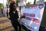 Pegiat merapihkan spanduk anti narkoba yang tersusun sepanjang 2015 meter di Jalan Yos Sudarso, Jakarta, Sabtu (27/6). Pemasangan poster itu tercatat sebagai yang terpanjang di Indonesia dan dilakukan dalam rangka memperingati Hari Anti Narkoba Internasional (HANI 2015). ANTARA FOTO/Akbar Nugroho Gumay/ed/foc/15.