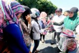 Polisi Syariat Islam atau Wilayatul Hisbah dibantu Satpol PP dan aparat TNI/Polri membagikan selendang dan jilbab kepada warga yang memakai pakaian ketat saat razia penegakkan syariat islam pada bulan Ramadan di Banda Aceh, Aceh, Kamis (2/7). Razia yang menjaring puluhan wanita memakai pakaian ketat dan pria memakai celana pendek untuk menegakkan peraturan daerah (qanun) nomor 11 tahun 2002, 12, 13 dan 14 tahun 2003 tentang syariat islam di provinsi Aceh. ANTARA FOTO/Irwansyah Putra/Rei/nz/15.