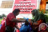 Warga menerima bantuan paket sembako untuk Ramadan dan Idul Fitri yang disalurkan Yayasan Hakka Aceh di Desa Peunayong, Kecamatan Kuta Alam, Banda Aceh, Minggu (5/7). Pembagian 1.500 paket sembakoyang digelar setiap tahun itu merupakan wujud toleransi dalam kehidupan bermasyarakat tanpa membedakan suku, ras dan agama. ANTARA FOTO/Irwansyah Putra/asf/aww/15.