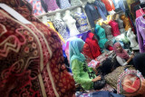 Pedagang melayani permintaan baju baru di blok pedagang pakaian, Pasar Besar Tulungagung, Jawa Timur, Rabu (8/7). Menjelang Lebaran, sejumlah pedagang mengaku penjualan aneka produk pakaian baru dan busana muslim meningkat 200 persen dengan omzet mencapai Rp25 juta hingga Rp30 juta per hari dari sebelumnya hanya di kisaran Rp10 juta per hari. Antara Jatim/Foto/Destyan Sujarwoko/Oka/15