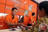 Petugas melayani transaksi penarikan uang kiriman TKI (remiten) di PT Pos Indonesia cabang Tulungagung, Jawa Timur, Rabu (8/7). Frekuensi pengiriman uang dari luar negeri oleh Tenaga Kerja Indonesia (TKI) di PT Pos Indonesia mengalami peningkatan sekitar 10 persen, dari sebelumnya rata-rata 800 transaksi menjadi 900 transaksi per hari dengan total nominal uang remiten mencapai Rp1 miliar hingga Rp1,5 miliar, dan diperkirakan akan terus meningkat hingga H-1 Lebaran. Antara Jatim/Foto/Destyan Sujarwoko/Oka/15