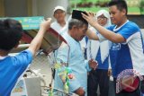 Seorang siswa SMP Muhammadiyah 5 Surabaya memakaikan songkok pada penarik becak di Surabaya, Jawa Timur, Kamis (9/7). Siswa SMP Muhammadiyah 5 Surabaya melakukan aksi simpatik di antaranya menghias becak dengan  harapan tidak ada kecelakan angkutan mudik pada Lebaran 2015. Antara Jatim/Andy Pinaria/SHP/15.