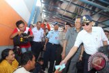 Menteri Perhubungan Ignasius Jonan didampingi Gubernur Kalsel Rudy Ariffin  mengembalikan tiket yang dipinjamnya kepada calon penumpang kapal laut saat meninjau arus mudik di pelabuhan Trisakti Banjarmasin, Rabu (15/7). TNI AL menyiapkan kapal sapujagat KRI Teluk Hading berkapasitas 500-700 penumpang untuk membantu arus mudik menuju Surabaya. Foto Antaranews Kalsel/Herry Murdy Hermawan