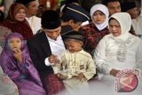 Presiden Joko Widodo (kedua kiri) didampingi Ibu Negara Iriana Joko Widodo (kanan) membagikan uang lebaran kepada anak-anak saat bersilaturahmi dengan warga di Kampung Punge, Kecamatan Jaya Baru, Banda Aceh, Jumat (17/7). Presiden beserta Ibu Negara Iriana Joko Widodo merayakan Idul Fitri 1436 H di Banda Aceh, Presiden juga bersilaturahmi dan memberikan bantuan paket sembako kepada warga. ANTARA FOTO/Yudhi Mahatma/hp/15