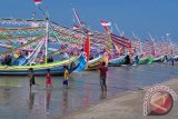 Sejumlah warga menyaksikan deretan perahu hias, di Pantai Wisata Jumiang, Pamekasan, Jatim, Senin (20/7). Puluhan perahu dihias untuk memeriahkan pelarungan sesaji pada upacara Petik Laut yang akan berlangsung dari tanggal 20-22 Juli 2015. Antara Jatim/Foto/Saiful Bahri/15