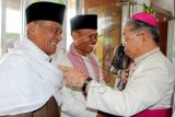 Uskup Amboina Mgr Petrus Canisius Mandagi MSC (kanan) menyalami Imam Masjid Istiqlal-Jakarta, Ahmad Husni Ismail (tengah) dan Imam Masjid Raya Alfatah-Ambon, H Hasanusi (kiri) saat silaturahmi Idul Fitri 1436 Hijriah yang digelar Pemerintah Provinsi (Pemprov) Maluku di kantor Gubernur Maluku, Ambon, Jumat (17/7). Para pejabat sipil maupun militer, tokoh agama maupun masyarakat memadati silaturahmi tersebut. ANTARA FOTO/izaac mulyawan/hp/15