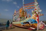 Warga menyaksikan perahu hias di Pantai Wisata Jumiang, Pamekasan, Madura, Jatim, Senin (20/7). Puluhan perahu dihias untuk memeriahkan pelarungan sesaji pada upacara Petik Laut yang diselenggarakan pada 20-22 Juli 2015. ANTARA FOTO/Saiful Bahri/wdy/15