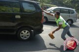 Penjaja jasa ganjal ban mobil mendorong kendaraan pemudik di tanjakan Lingkar Gentong, Tasikmalaya, Jawa Barat, Senin (20/7). Penjaja jasa ganjal ban memanfaatkan kondisi tanjakan curam di kawasan Gentong yang membuat sebagian kendaaran pemudik tidak kuat menanjak sehingga harus diganjal dengan kayu. ANTARA FOTO/Adeng Bustomi 