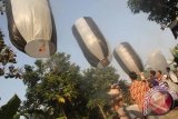 Warga melepas balon udara/asap usai menunaikan ibadah sunah salat jamaah Dhuha dalam rangka perayaan Lebaran Ketupat di Trenggalek, Jawa Timur, Jumat (24/7). Lebih dari seribu balon udara atau balon asap dilepas secara sporadis oleh masyarakat muslim daerah itu untuk memeriahkan pesta rakyat Lebaran Ketupat pada H+8 Hari Raya Idul Fitri 1436 Hijriah. Antara Jatim/Destyan Sujarwoko/15