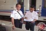 Kepala PT KAI Daop VII Madiun Windar Prihadi Adji (kiri) memantau kondisi stasiun di Stasiun Kediri, Jawa Timur, Minggu (26/7). Jumlah penumpang yang naik kereta api di wilayah Daop VII Madiun masih banyak, sehingga pihak daop mengajukan tambahan kereta api luar biasa yang beroperasi pada 26 sampai 30 Juli 2015. Antara Jatim/Foto/Asmaul Chusna 
